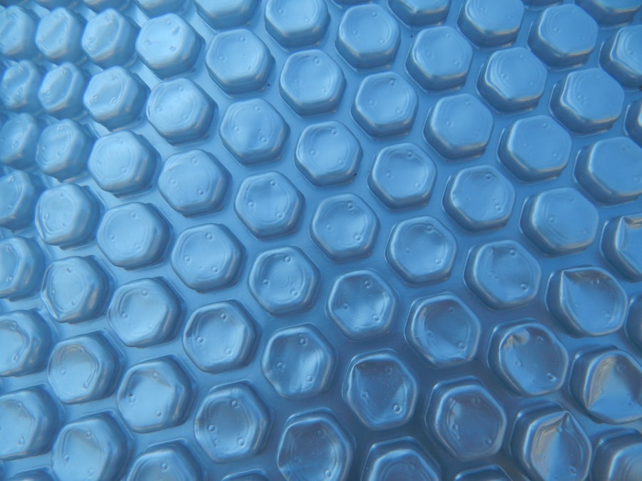 A blue bubble solar cover floating on the surface of a pool