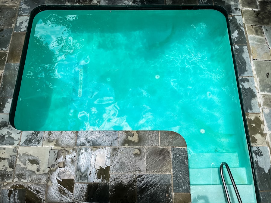 A built-in spa with turquoise water set into a stone surround