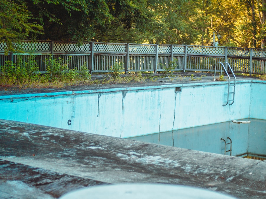 an empty swimming pool surrounded by a wooden fence