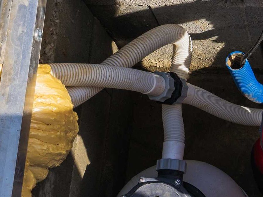 Pool pump and suction hoses in an equipment pit