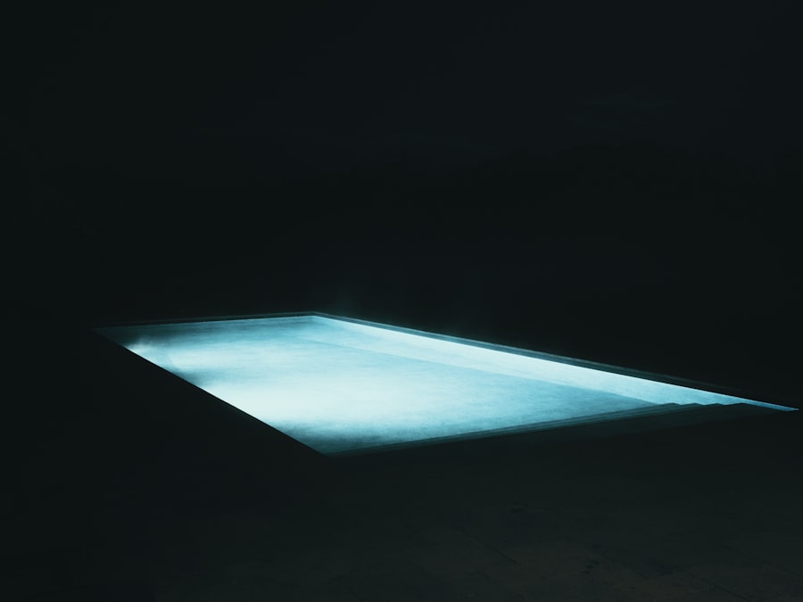 A glowing blue swimming pool at night