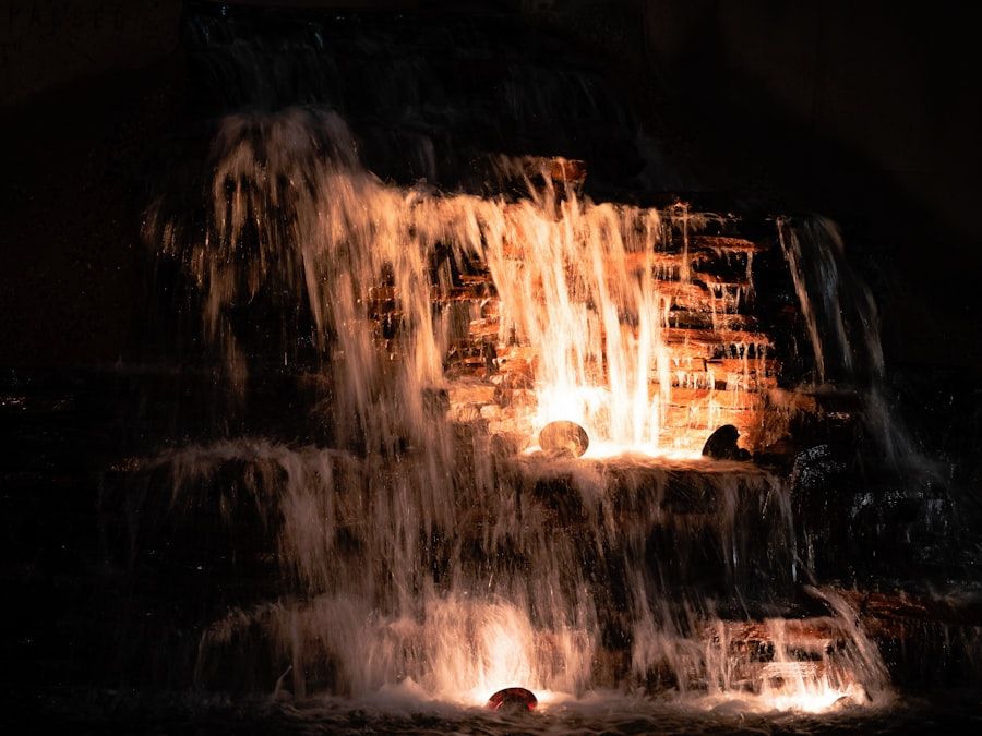 Illuminated waterfall cascading down rocks at night