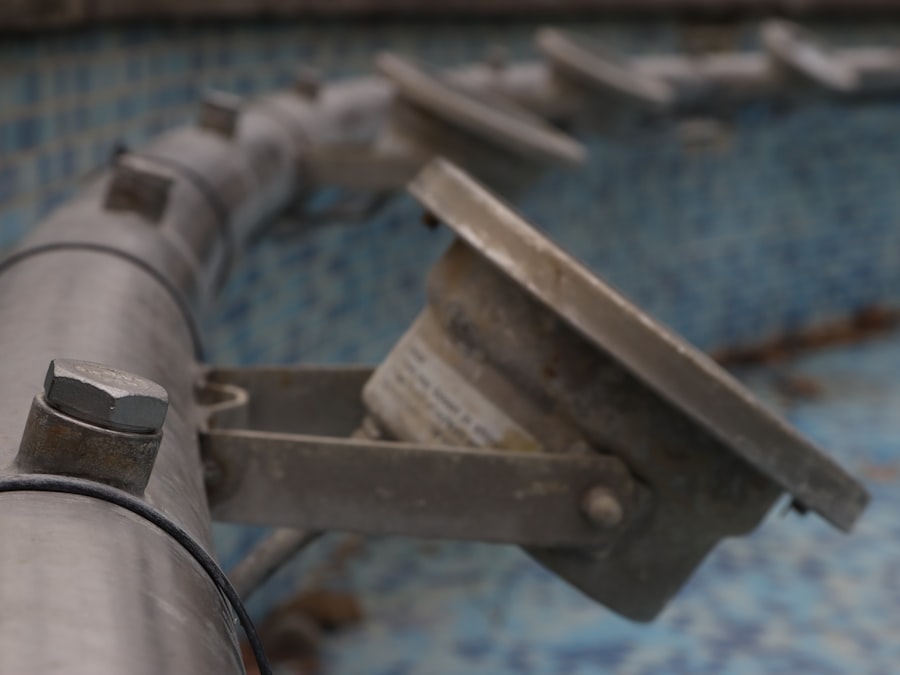 A pool fitting and pipework at the tiled edge of a pool