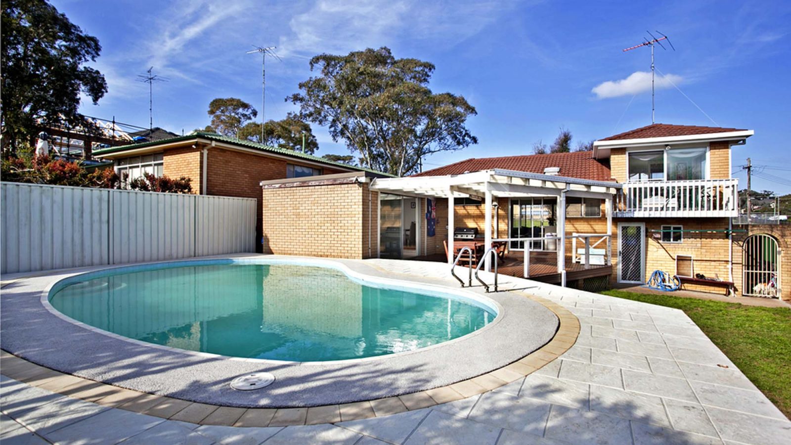 Inground pool beside a single storey home