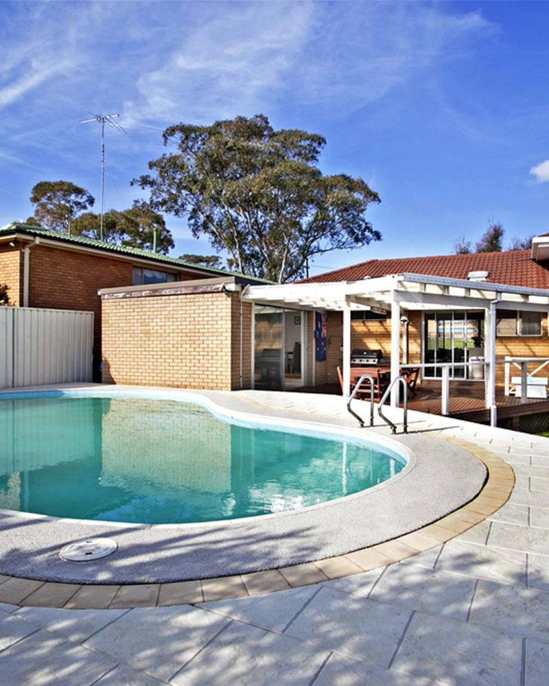 Inground pool beside a single storey home