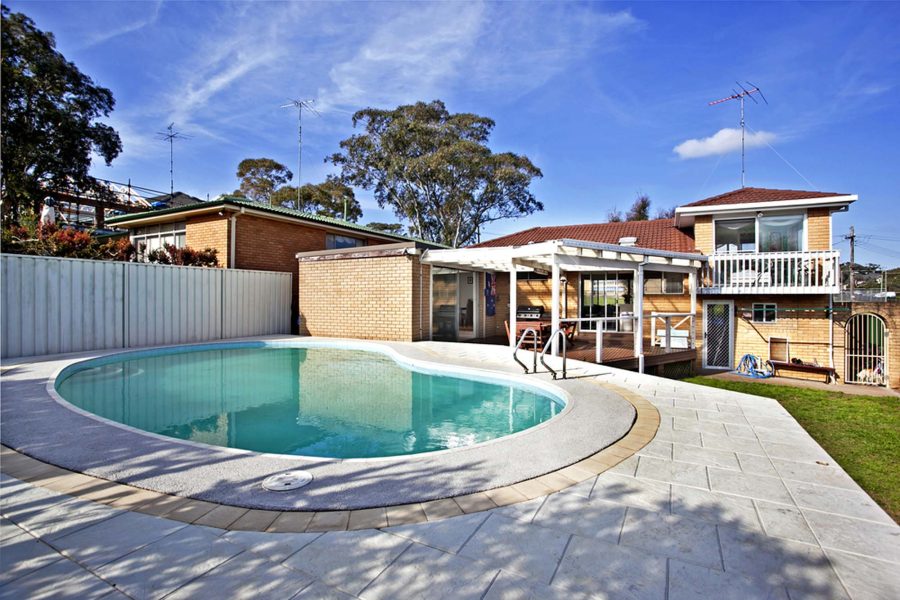 Inground pool beside a single storey home