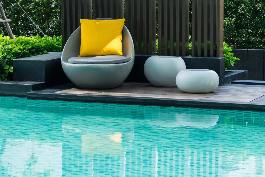 Modern pool with turquoise tile and poolside seating