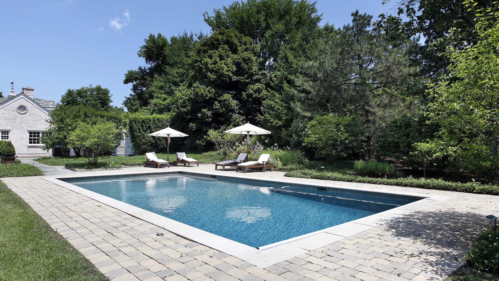Rectangular pool with a paver deck and loungers