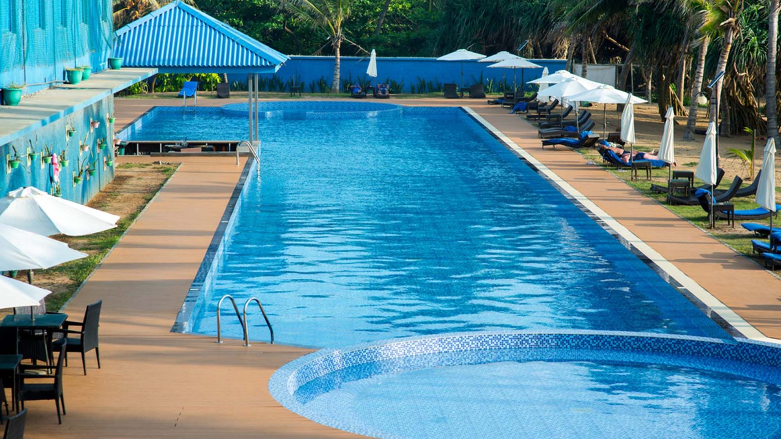 Resort-style pool with shaded loungers